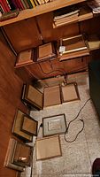 Photo of multiple metal framed picture frames laid out on floor and shelf, showing sizes and finishes