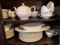 Top shelf view showing teapot centered with surrounding bowls and saucers