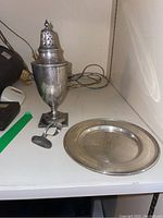Full-lot view showing silver shaker, baby food pusher, and round dish