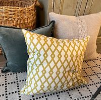 Group of three throw pillows showing full front designs and colors