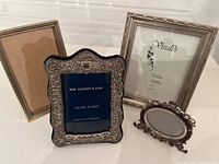 Four small assorted picture frames shown together on a white surface.