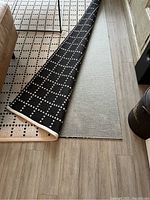 Rolled edge showing both black side with cream grid and reverse cream side with black grid