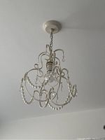 View of entire cream-colored bead and crystal chandelier hanging from ceiling