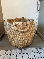 Front view of the large woven sea grass basket showing its textured weaving and handles.