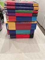 Stack of Harry Potter books including a mix of paperback and hardcover editions.
