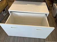 Front view of the IKEA SMASTAD white wooden bench unit with the large pull-out storage drawer open, showing the drawer interior.
