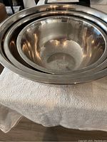 Top angled view of nested metal mixing bowls showing the interior and size variation of three bowls.