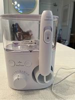 Front view of Philips Sonicare Power 5000 series water flosser with transparent water tank, control dial, clean/deep clean buttons, and handheld flosser inserted in holder.