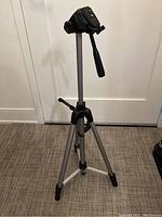 Full view of the lightweight tripod with extended legs and mounted 3-way head with handle.