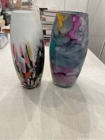 Pair of tall oblong glass vases showing different abstract multicolour patterns on each glass vase.