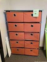 Front view showing the full 10-drawer organizer with gray metal frame and orange fabric drawers.