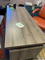 Top view of the desk showing wood grain finish surface and metal leg frame.