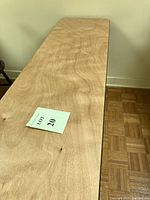 Top view of rectangular table with natural woodgrain finish and lot number card.