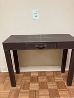 Front view of the faux leather sofa table with drawer showing its rectangular shape and centered drawer.