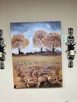 Close-up of large canvas print showing trees with rust, orange, and moss colored leaves, lower field in foreground.