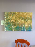 Front view of canvas depicting white birch trees in shades of green, yellow, white, and orange with textured paint.