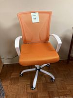 Front view showing the orange mesh backrest, cushioned seat, white armrests, and the note indicating lot 16.