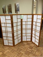 Full view of the 4-panel room divider showing honey color wood frame and white rice paper panels with grid detailing.
