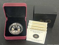 2013 Canadian $20 silver coin displayed in a red hinged case with original certificates and a black outer box.