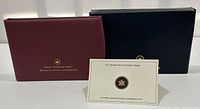 Front view of two Royal Canadian Mint cases and a card certifying the 2013 Specimen Set