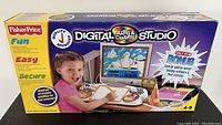 Front view of the Fisher-Price Digital Arts & Crafts Studio software box showing branding, age range (4-9), and promotional text for special holiday software and stencils.