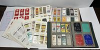 Overview of four binders with plastic sleeves containing vintage matchbook covers, some loose pages included.