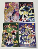 Set of four Sailor Moon graphic novel paperbacks, volumes 1-4 arranged in two rows.