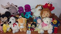 Wide shot showing an assortment of 17 vintage stuffed animals from recognizable characters and franchises.