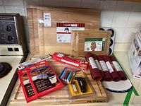 View of entire baking tools lot including silicone mats, wooden pastry boards, bamboo board, gloves, muffin tins and accessories.