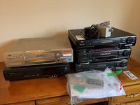 Overview of four JVC VCRs stacked and Panasonic Desktop Editor with remote control and cables