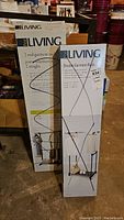 Two boxed For Living garment racks, one 2-rod garment rack and one double garment rack.