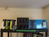 Wide shelf shot showing three WD My Passport boxes, four Bytecc Eagle Carry enclosures, cable pouch, DVD case stack, and one WD My Book box.