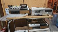 Overall view of two cassette decks side by side on a wooden shelf