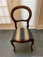 Single front view of one chair showing balloon-back design and upholstery