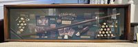 Billiard history shadow box with ball racks, cues, and vintage elements