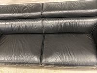 Close-up of seat cushions and lower backrest showing leather surface and wear