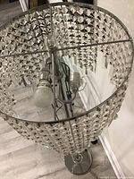 Close-up view inside the shade showing two light sockets and crystal prism decorations.