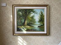 Front view of the framed oil painting showing full forest river landscape