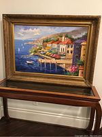 Full view of framed painting on wooden stand