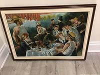 Full view of the framed painting depicting a group gathering outdoors under a red canopy.