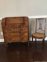 Full view of secretary desk and wicker chair side by side