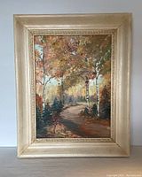 Full view of framed oil painting showing autumn forest path landscape.