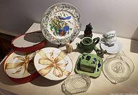 Full view of all items showing plates, ceramic figures, glassware including the teapot and decanter, and boxed serving plates