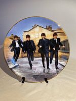 Front view of the Beatles limited edition porcelain plate featuring the iconic running scene from "A Hard Day's Night", showing four band members dressed in suits with a gold rim around the plate.