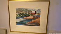 Framed watercolour landscape painting featuring a river, shoreline, and barn under a cloudy sky.