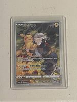 Front of the Japanese Pokémon card featuring Pikachu with a resting character in a forest setting.