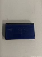 Closed blue Nintendo DS Lite top view showing outer shell and model logo.