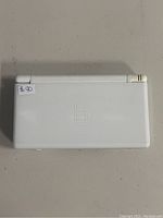 Closed top view of the white Nintendo DS Lite handheld console showing the Nintendo DS logo embossed on the cover.