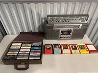Sony boombox, cassette tapes in case, and 8-track tapes spread on table