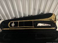 Full view of Yamaha Advantage trombone inside black hard case with plush interior and cleaning cloth.